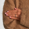 Model 1541975, elegant guldring med diamanter bæres på hånd med nude negle og camel strik.