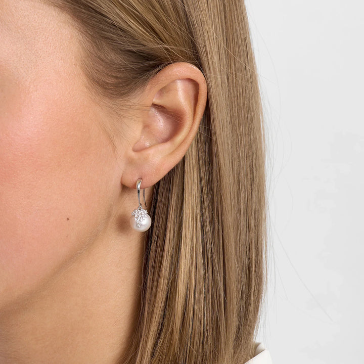 Silver earring with white pearl and stone, shown on the ear, model 2113025, front