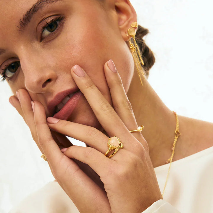 Gold earrings, necklace and rings with pearl on model, jewelry close-up