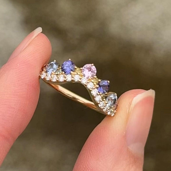 anpe-atelier-josephine-ring-with-pastel-sapphires shown close-up, curved design with multicolored gemstones in gold. Model 2458-pastel-001.