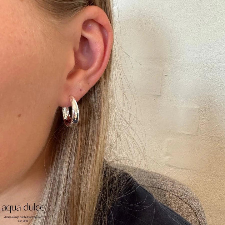 aqua dulce Big Emma Hoop silver earring shown on ear, shiny silver finish in simple and elegant style. Model 5534-5534-2