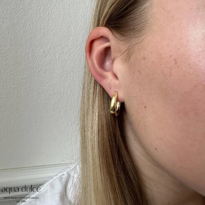 Aqua Dulce Big Emma Hoop silver plated earring shown on ear, shiny gold finish. Model 5535-5535-2