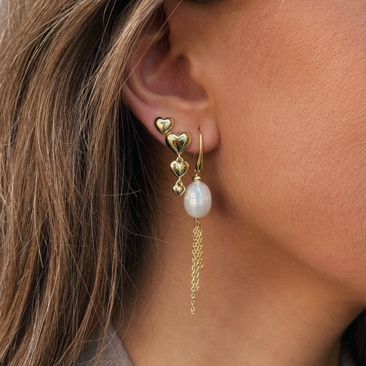 Aqua Dulce Karla And Me Long Earrings shows an elegant gold earring with heart-shaped details and pearl pendant, Model 6422-2.