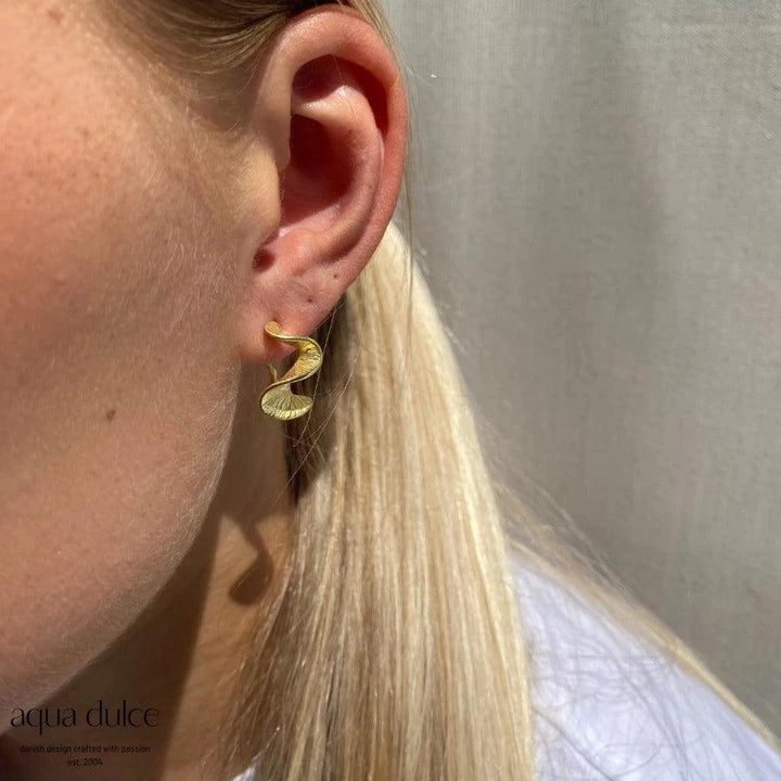 Aqua Dulce Rhumba Medium Hoop Creole in matte gold-colored look worn in the ear, model 5320-5320-2.