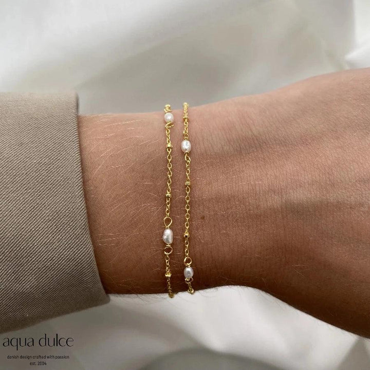 aqua dulce rice dot double bracelet with gold-plated chain and small white pearls on the wrist. Model 5372-5372-2