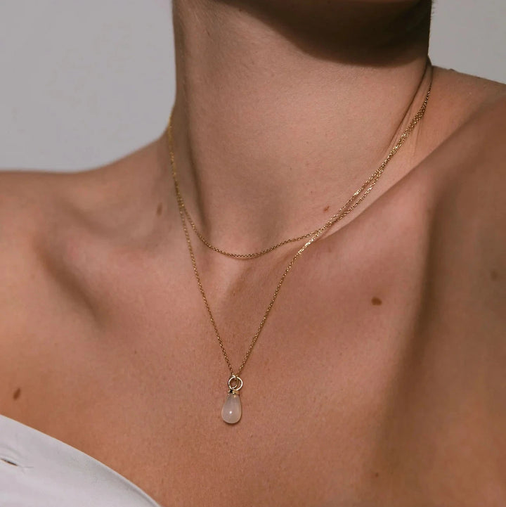 carre-10-karat-drop-wood pendant-m-manesten beautiful drop pendant in gold with white stone on model. Model TL4395MO-2