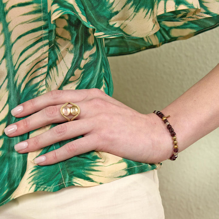 carre-simone-bracelet-with-garnet-golden-bead-and-labradorite seen on hand, garnet red and golden beads. Model fb4658gabglb