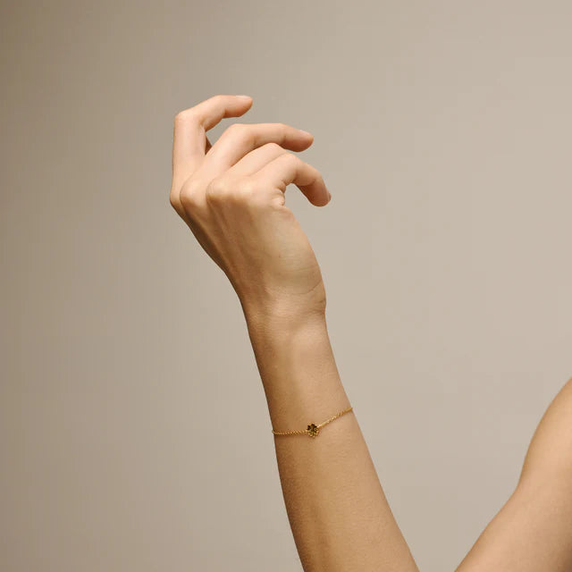 enamel-four-leaf-clover-bracelet-in-gold-plated-sol is worn on the wrist, thin chain bracelet in gold look with small clover detail. Model b148gm-2