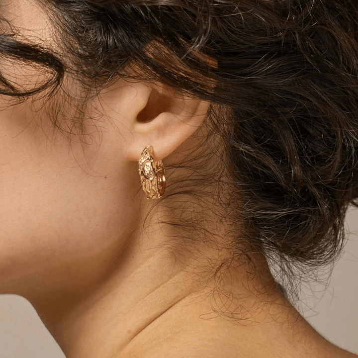 Enamel Nela gold-plated hoops 20 mm appear in the ear, elegant golden hoop with raw texture. Model E370GM.