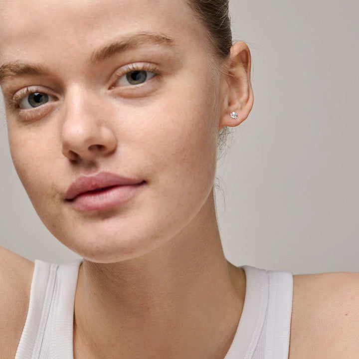 Enamel Organic Clover Small Four-Clover Earrings in silver can be seen on the ear of model, discreet design Model e412sm