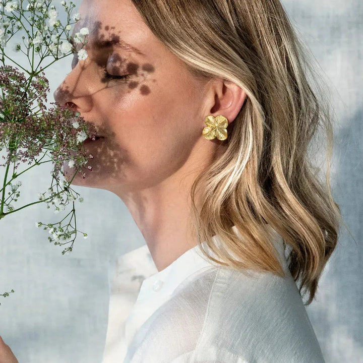 Flora Danica Fir Clover Ear Clips worn by woman with short light curls, gilt floral detail. Model 907-flc-eaclips-g-2