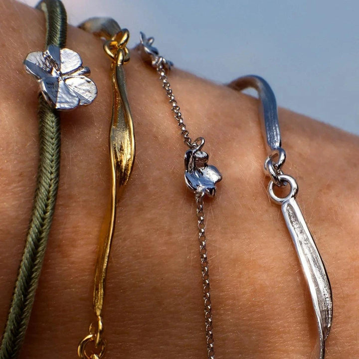 Flora Danica Clover Silk Bracelet Olive Silver can be seen on the wrist, olive green silk cord and clover detail. Model907-FLC-SILK-OLIVE-S-001-2