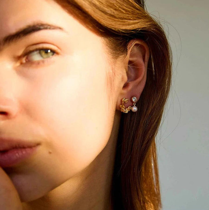 Hultquist Copenhagen Audrey Petite gold plated earrings with pearl and stone seen on ear, Model S08603G-2.