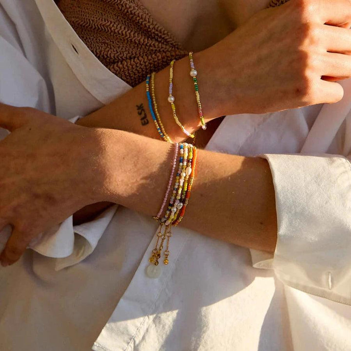 Hultquist Copenhagen Paisley Pearl Bracelet with colored pearls and pearl details on woman's arm in sunlight. Model S08619G-2