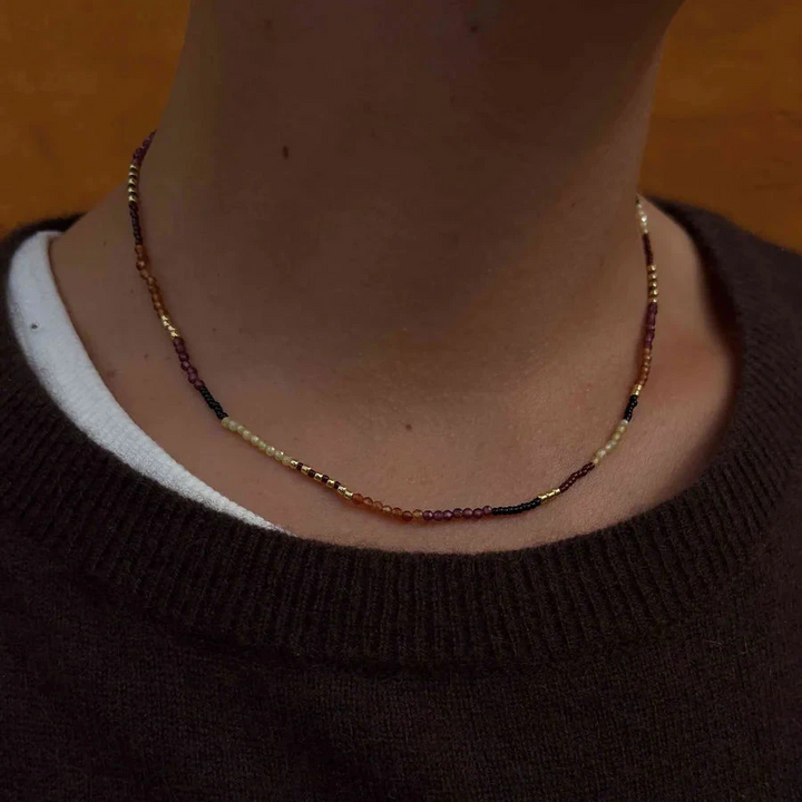 Hultquist Rowen Necklace is shown around the model's neck, with small colored beads in gold, orange and black. Model S08642G-2