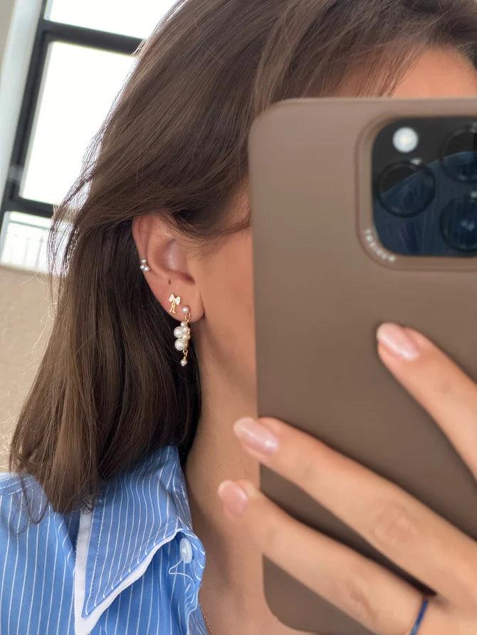 jeberg petite bow white stud bow earrings are worn in the ear, elegant design with pearl details. Model 52815-2