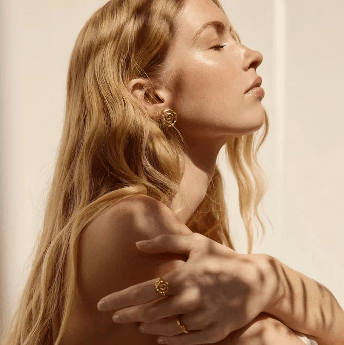 Jeberg Pirouette Darling earrings are shown on a woman, golden color, elegant style. Model 52870-2