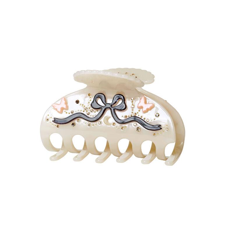 maanesten-desiree-hair-claw-off-white shows a cream colored acrylic hairclaw with decorative details and butterflies. Model 3973-one size