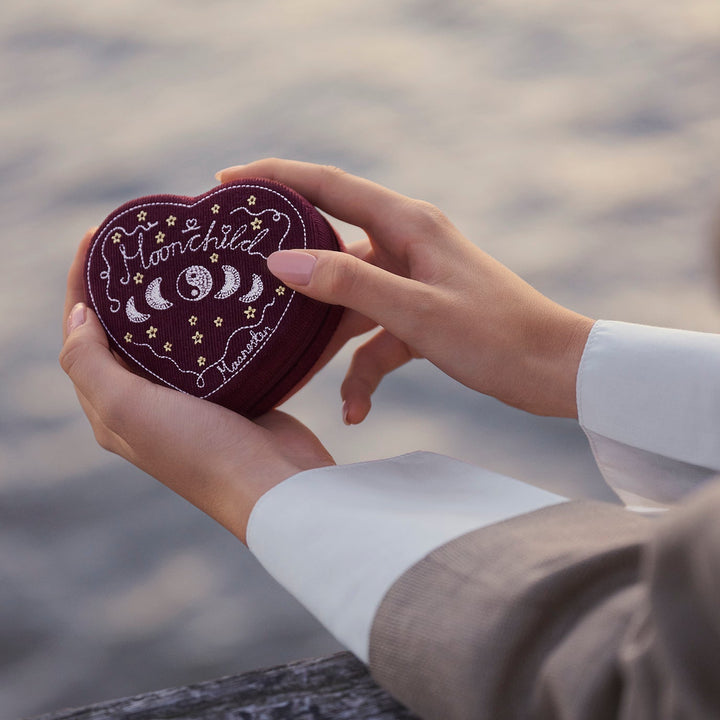 Maanesten Heart Jewelry Box Maroon appears in hands outdoors, dark red heart shape with embroidery. Model 2026-4207-1