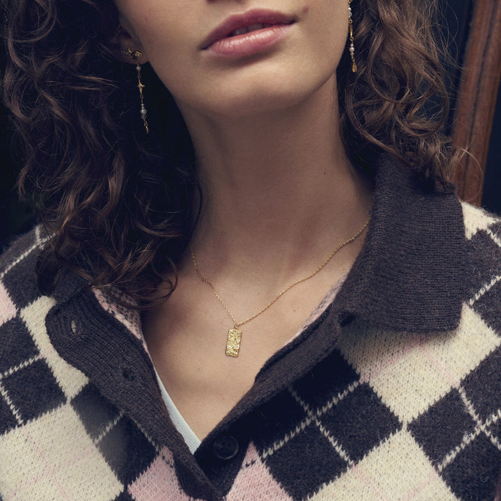 maanesten-notabene-gold-plated-necklace worn by woman, elegant square pendant in gold, Model 2802a-2