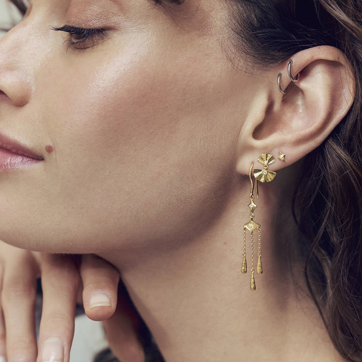 maanesten-odile-gold-plated-earrings appear on ear, elegant gold color design with drop pendant, Model 10039a