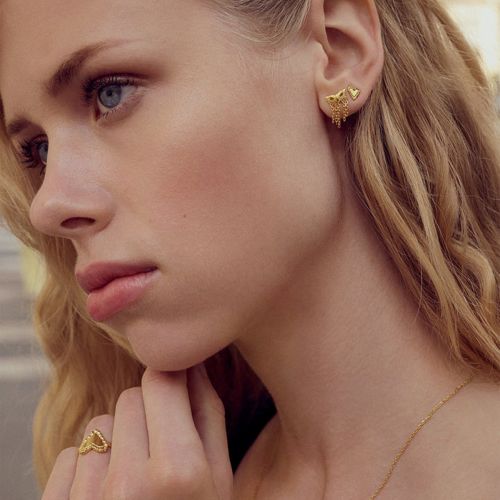 maanesten-rouge-gold-plated-heart studs shown on model, close-up of ear with golden heart studs. Model 10059a-2
