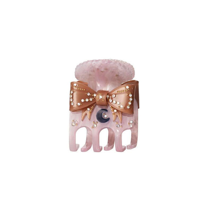 The Moonstone Ruku Hair Claw Dawn features a pink hair clip with a bow, pearl details and small stones. Model 3972-1.