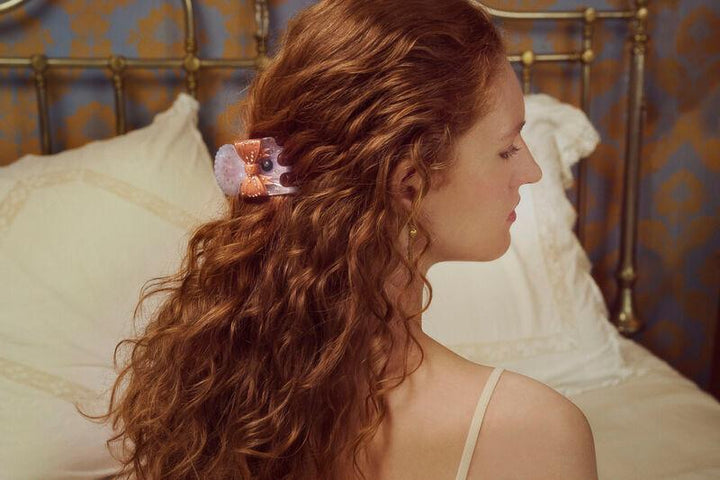 maanesten-ruku-hair-claw-dawn in purple and pink acrylic can be seen in long, wavy hair on a woman. Model 3972-2