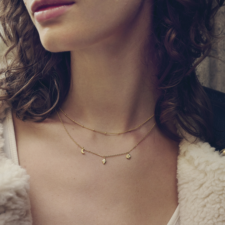 Maanestens Lea gold-plated necklace shown on model, elegant chain with small pendants in gold, Model 2806a-2