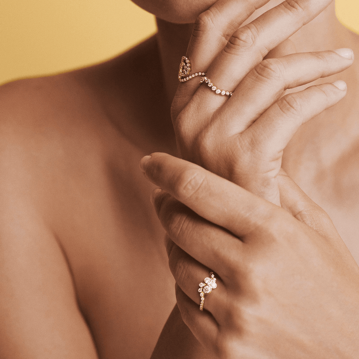 Mads Z Freya 14kt gold ring wave 0.28ct W/SI shown on woman's hand, elegant wave design with diamonds. Model 1541177-001