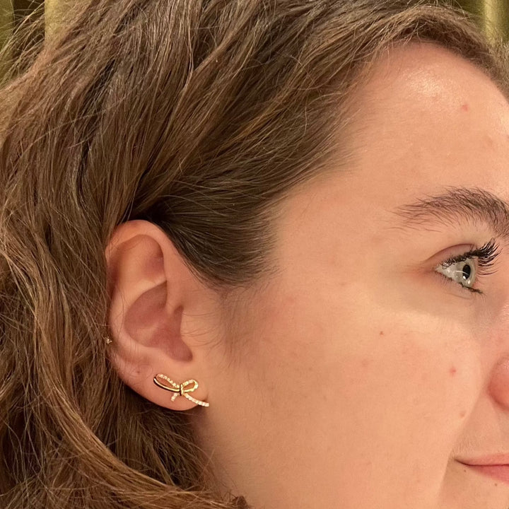 Mads Z Miss Butterfly bow earrings in gold with diamonds seen on woman's ear, Model 1511003-2