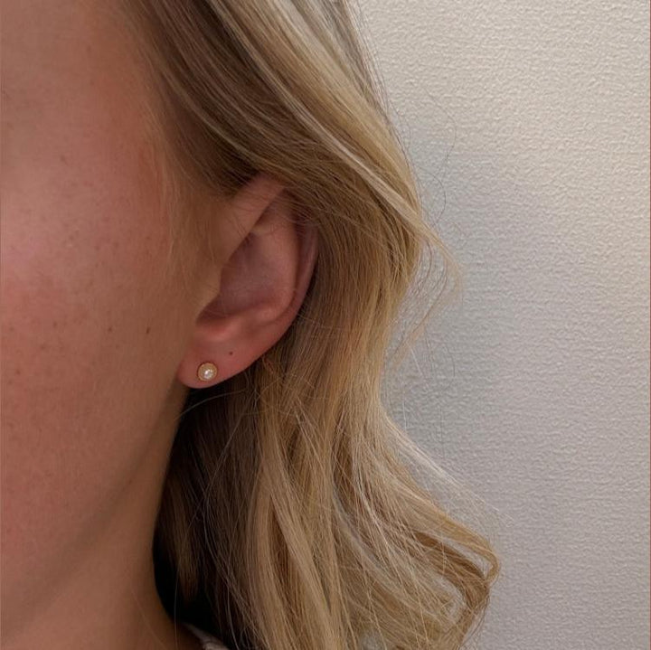 Mads Z Noelle pearl ear studs in 8kt gold are worn on the ear, discreet design with bright pearl. Model 3313123-2