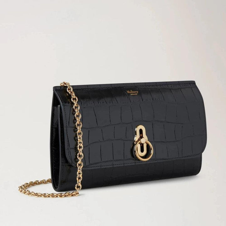 Mulberry Amberley Clutch Black Shiny Small Croc shows black clutch in shiny crocodile embossed leather, gold chain and clasp. Model RL8191641A100.