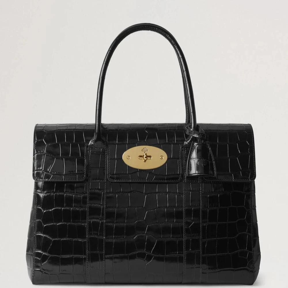 Mulberry Bayswater Croc Black shows an elegant black handbag in crocodile-embossed leather with a golden clasp. Model HH9589641A100