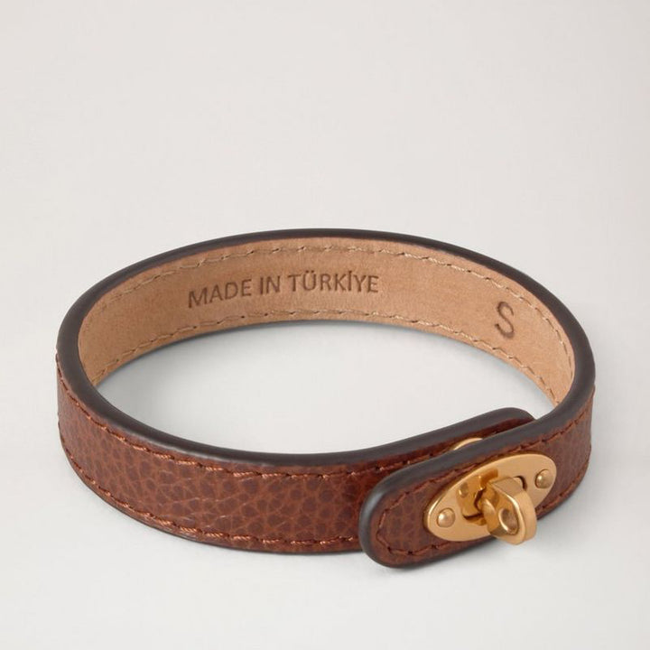 Mulberry Bayswater Thin Leather Bracelet Oak seen in close-up, leather bracelet in brown with gold buckle. Model QB2390205G110