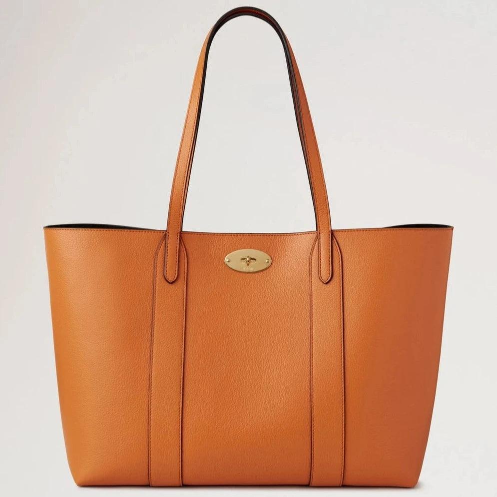 Mulberry Bayswater Tote Small Classic Grain Sunset showcases a roomy orange leather bag with gold detailing. Model hh7436205n691