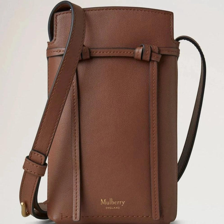 Mulberry Clovelly Phone Pouch Micro Classic Grain Oak features a compact brown leather phone pouch with adjustable strap. Model RL8557587G222.