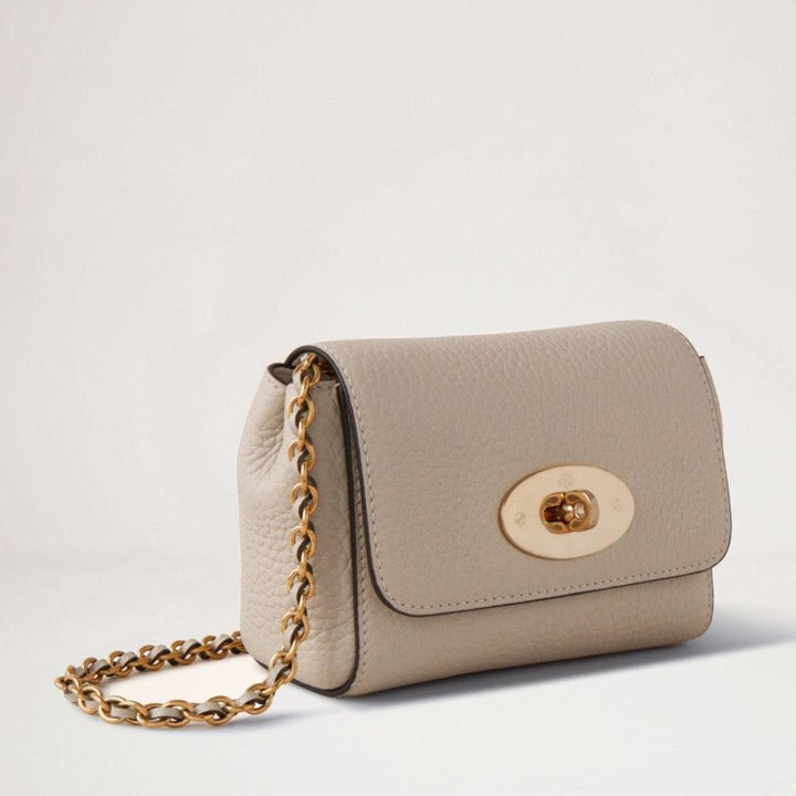 Mulberry Mini Lily Heavy Grain Chalk shows a small beige shoulder bag in heavy leather with a chain strap and golden buckle. Model RL7944736W160.