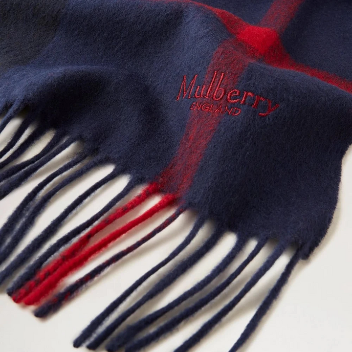 Mulberry Small Check Merino Wool Scarf Night Sky Lancaster Red shows close detail of soft wool with fringe and checked navy and red pattern, Model vs4319890u897.