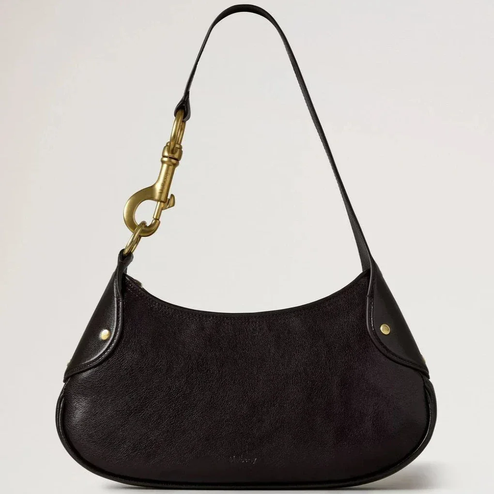 Mulberry Small Hackney Shoulder Bag Ebony Shiny Buffalo shows a dark shoulder bag in glossy leather with gold buckle. Model RL8929726A110.