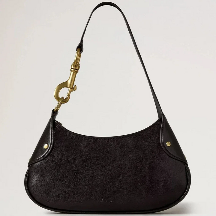 Mulberry Small Hackney Shoulder Bag Ebony Shiny Buffalo shows a dark shoulder bag in glossy leather with gold buckle. Model RL8929726A110.