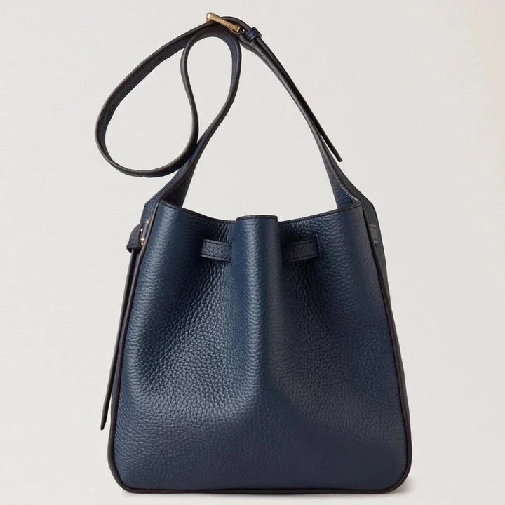 Mulberry Small Lyra Bucket Night Sky Heavy Grain shows a structured, dark blue leather bag with a long strap and discreet gold buckle. Model RL7866-205U918