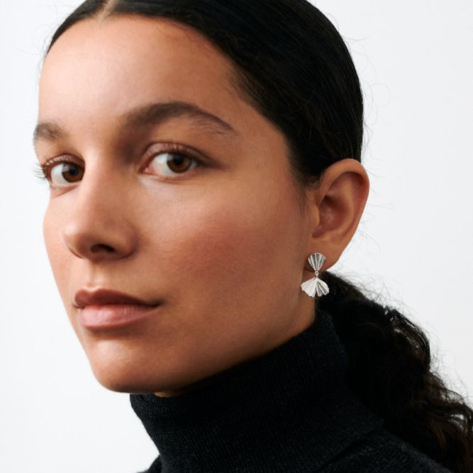 Pernille Corydon Autumn Leaf earrings in silver are shown worn by a woman with dark hair. Model e-497-s.