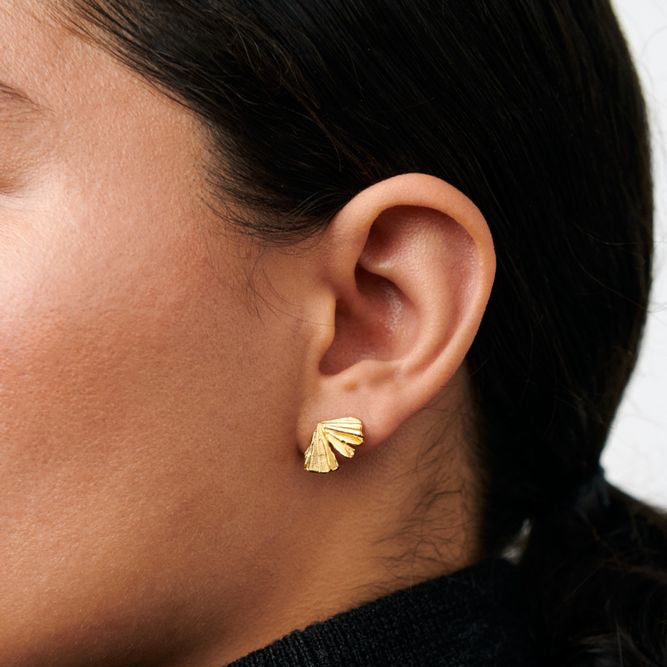 Pernille Corydon Autumn Leaf earrings in gold-plated silver, shown on ear, matte leaf-shaped detail. Model E-496-GP-1