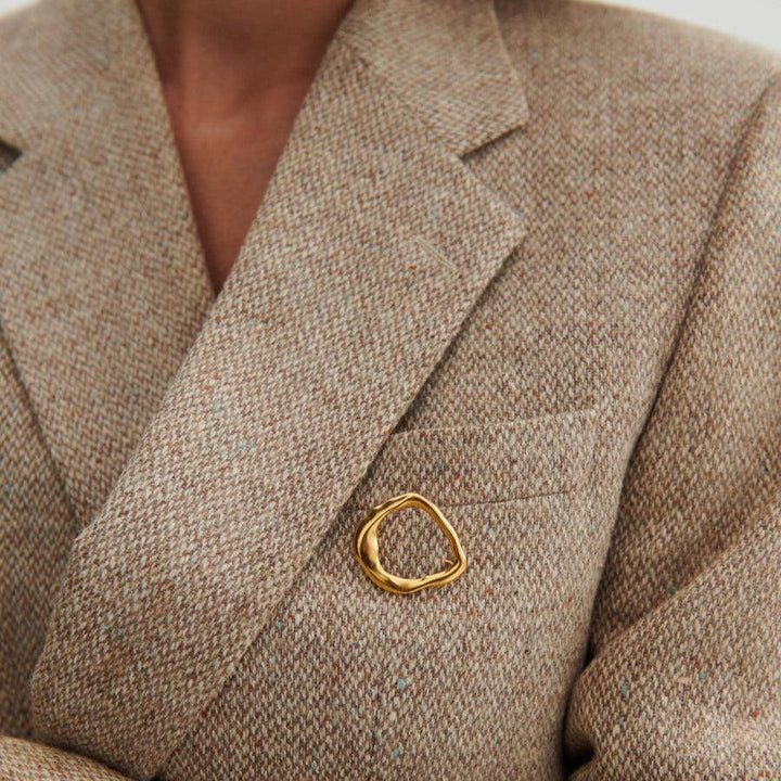 Pernille Corydon Gaia Gilt Silver Brooch Seen on a Beige Jacket, Organic Golden Shape, Model C-001-GP