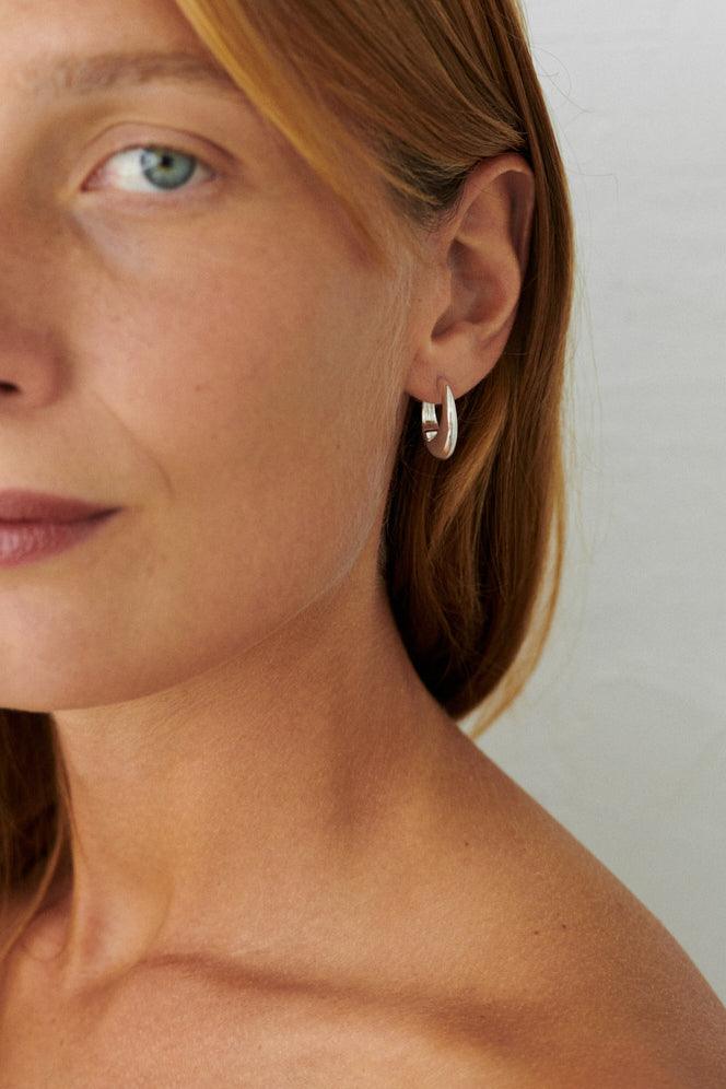 Pernille Corydon Globe Huggies in silver worn by model, simple and elegant style. Model E-401-S