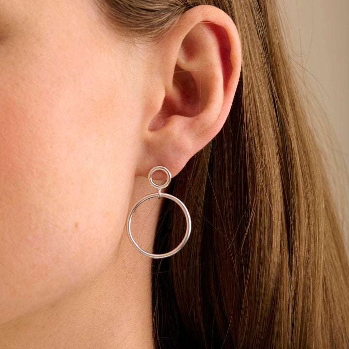 Pernille Corydon Globe earring in silver seen on ear, elegant stylish circle design. Model E-403-S-2.