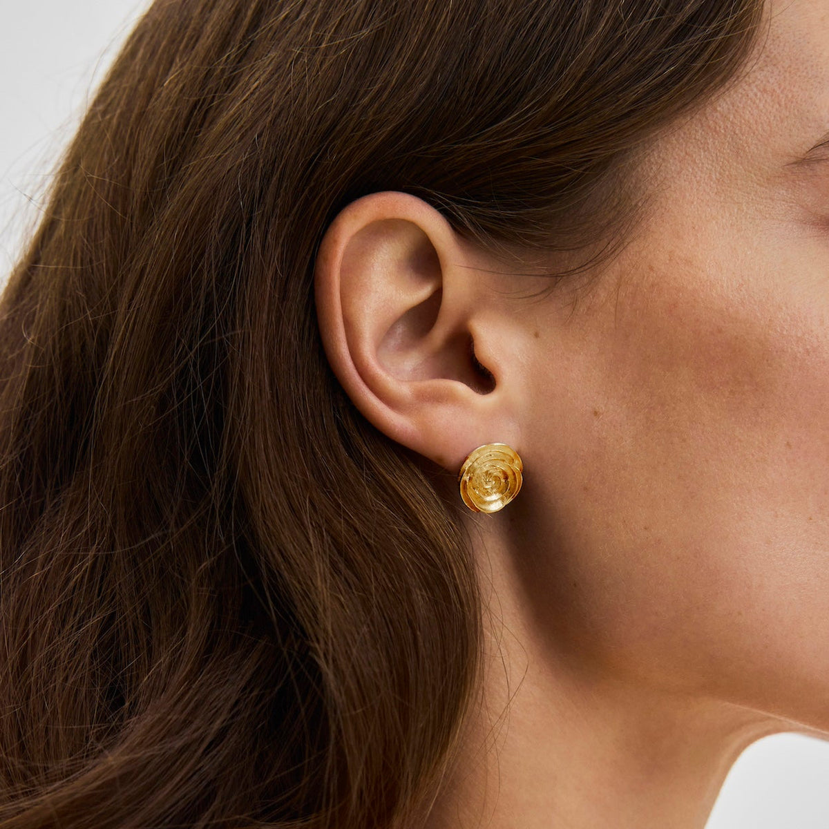 Pernille Corydon Large Rose Gilded Earrings on model, round golden earring in the ear. Model E-537-GP-1