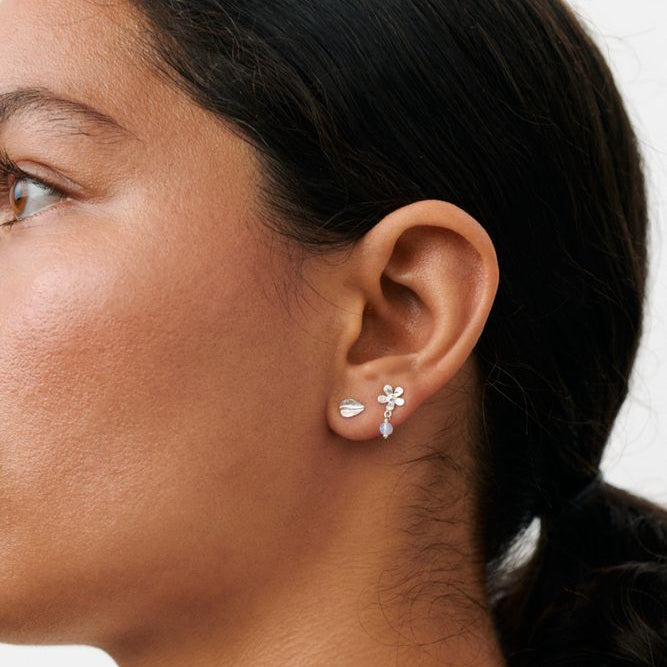 Pernille Corydon Meadow Earring Box in silver is shown in the model's ear, glossy finish and flower detail. Model C-121-S-1.