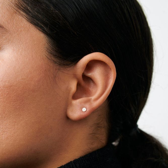 Pernille Corydon Micro Nature ear studs in gold-plated silver, shown on ear in close-up. Model E-390-GP